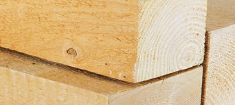 Nahaufnahme von Kanthölzern mit sichtbarer Holzmaserung, ideal für den Holzbau und konstruktive Anwendungen.